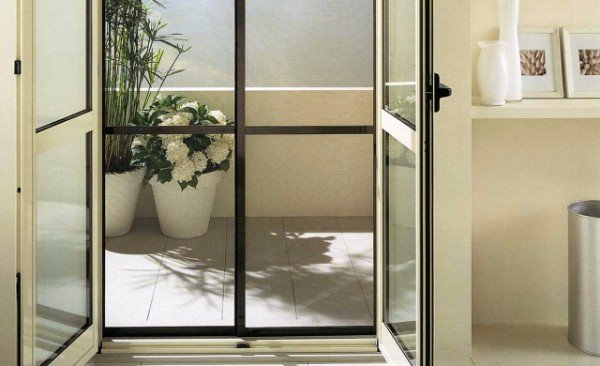 Zanzariera scorrevole installata su una portafinestra che si apre sul giardino